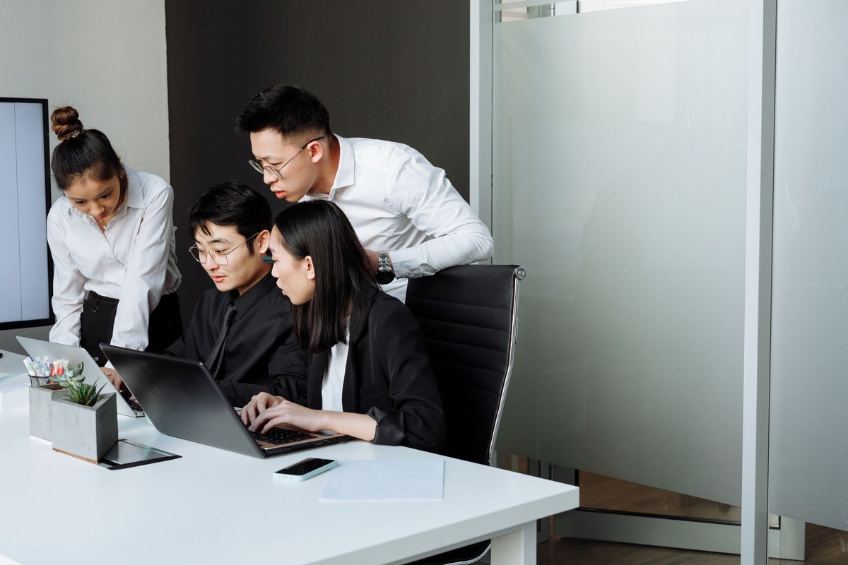 The DeltCode team working together on a project at a laptop